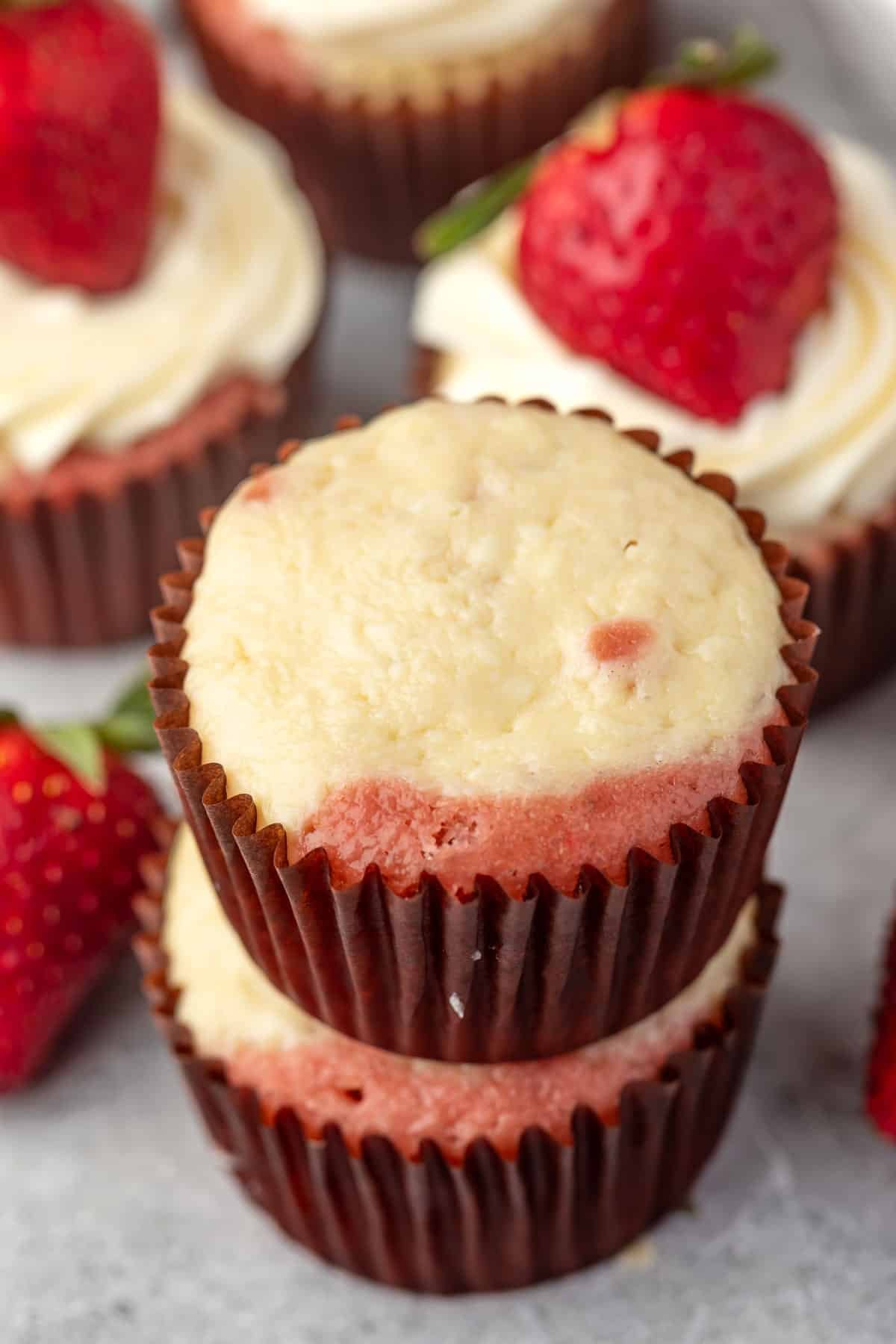 white and pink cupcake in a brown cupcake tin.