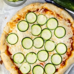 pizza with sliced zucchinis on top.