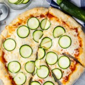 pizza with sliced zucchinis on top.