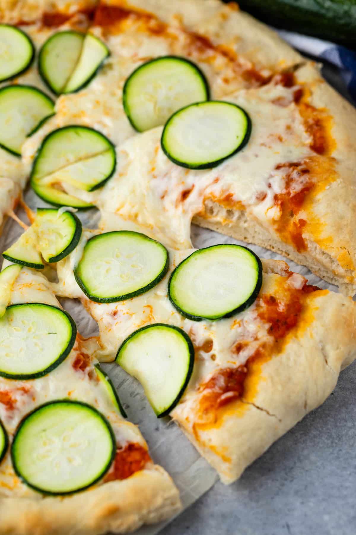 pizza with sliced zucchinis on top.