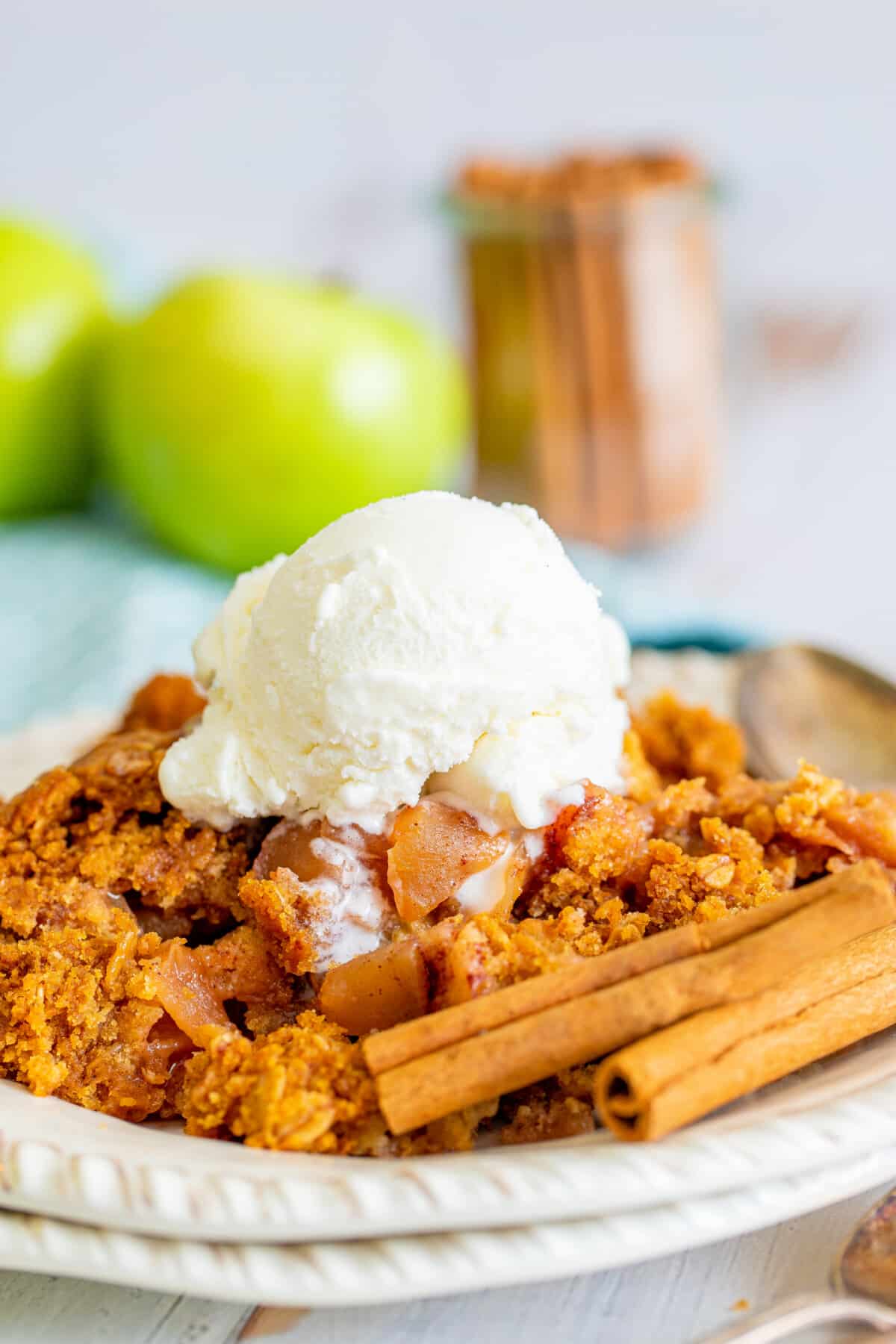 orange dump cake on a white plate with white ice cream on top.