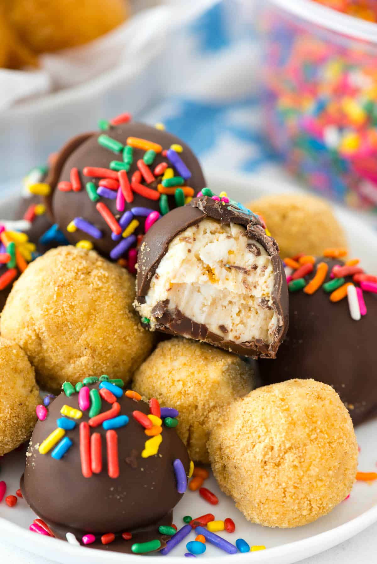 stacked truffles on a white plate. some are covered in chocolate and some are plain.