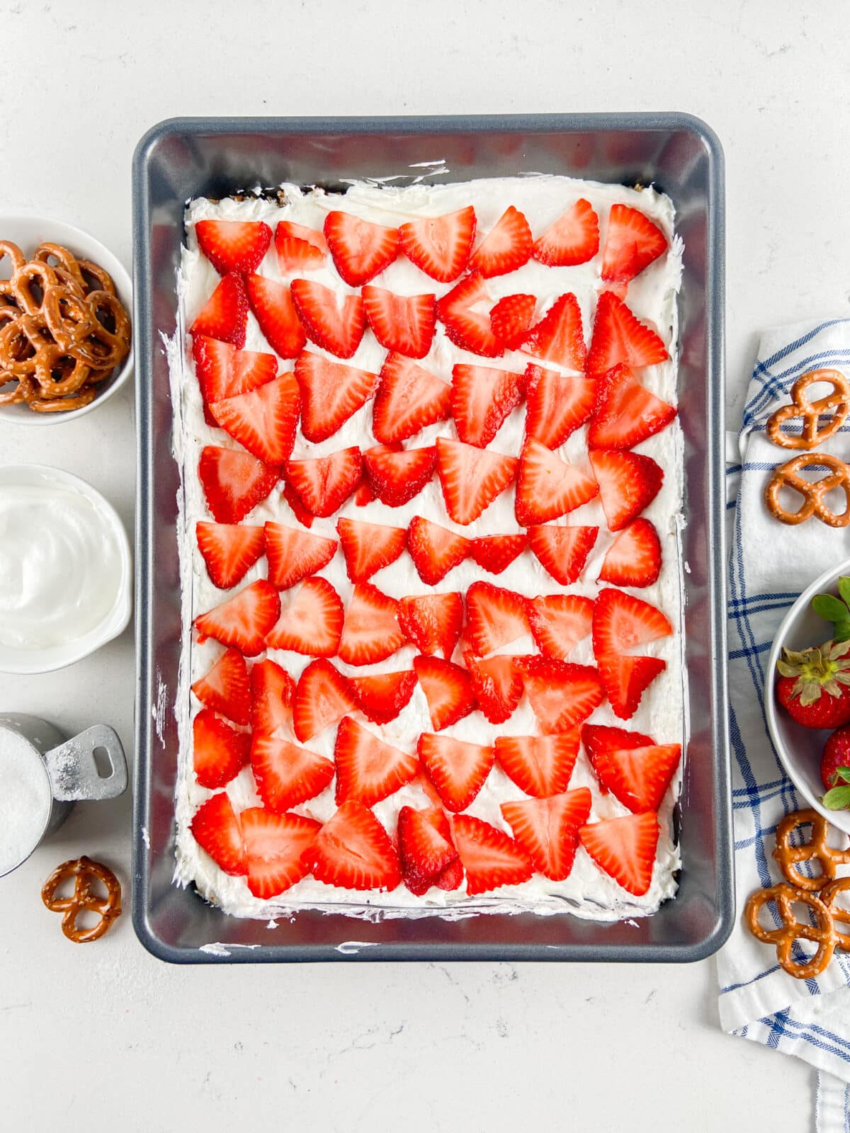 strawberries over cream cheese layer in pan.