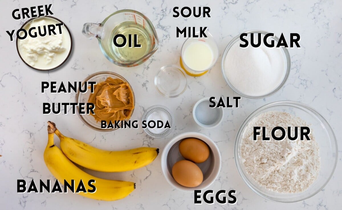 ingredients in banana bread laid out on a marble counter.