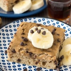square slice of pancake with sliced bananas and chocolate chips on top.