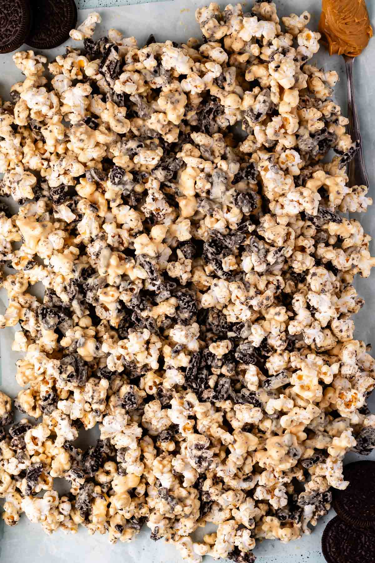 popcorn covered in melted chocolate and peanut butter laid out on parchment paper.