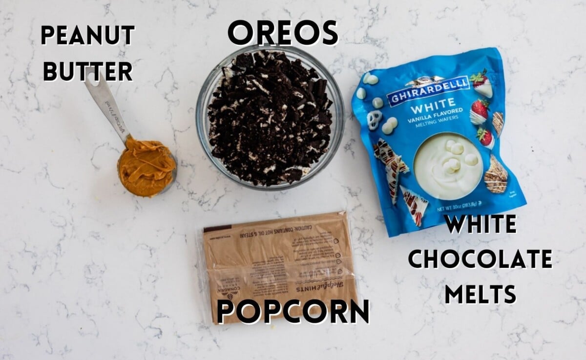 ingredients in oreo peanut butter popcorn laid out on a marble counter.