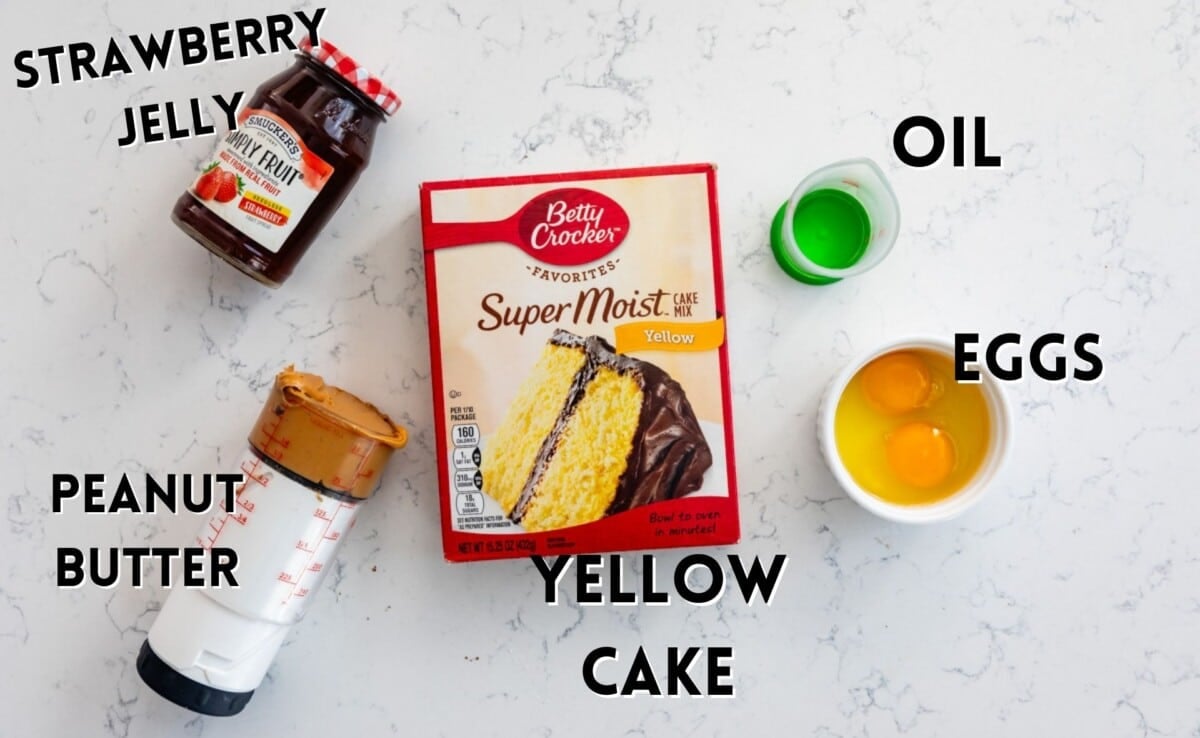 ingredients in peanut butter and jelly laid out on a marble counter.