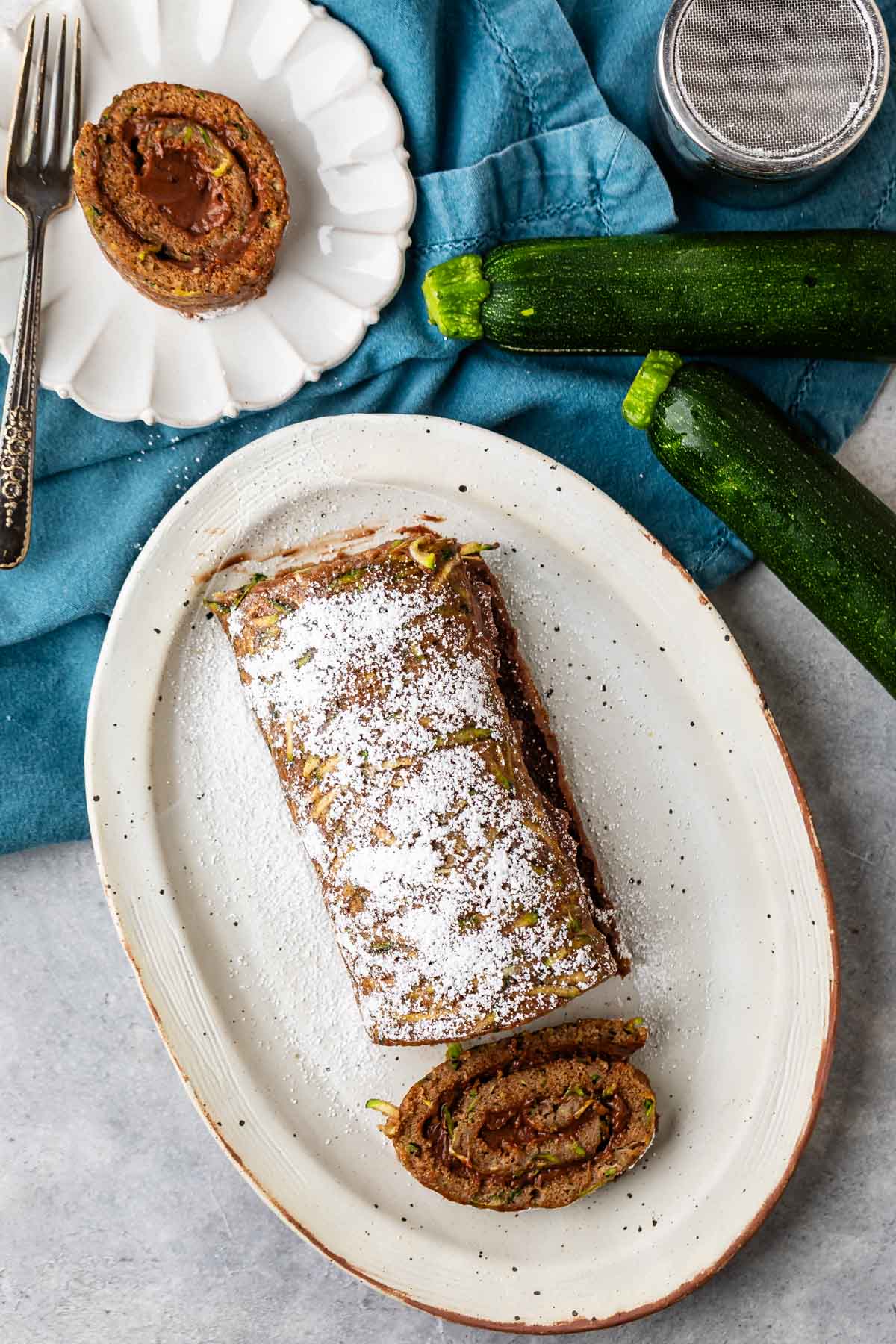 sliced cake roll with chocolate filling and powdered sugar sprinkled on top.