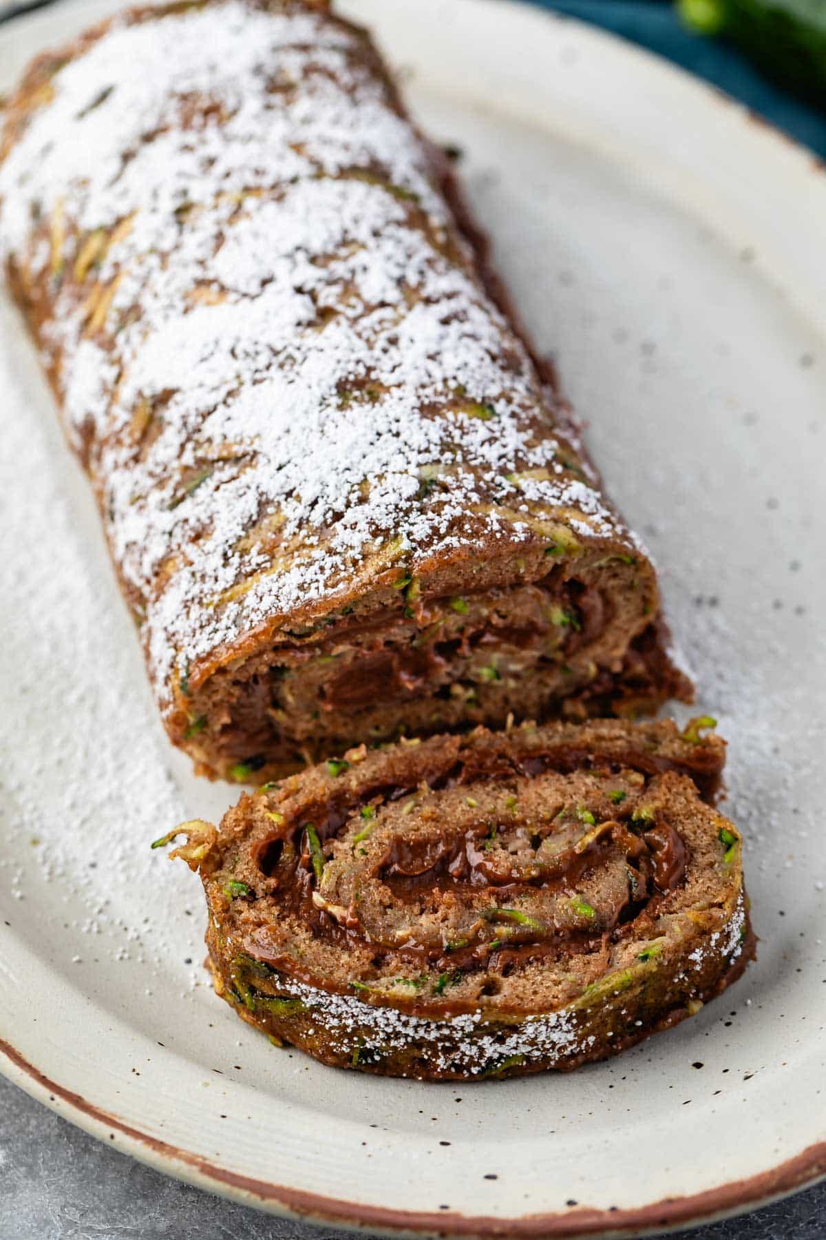 sliced cake roll with chocolate filling and powdered sugar sprinkled on top.