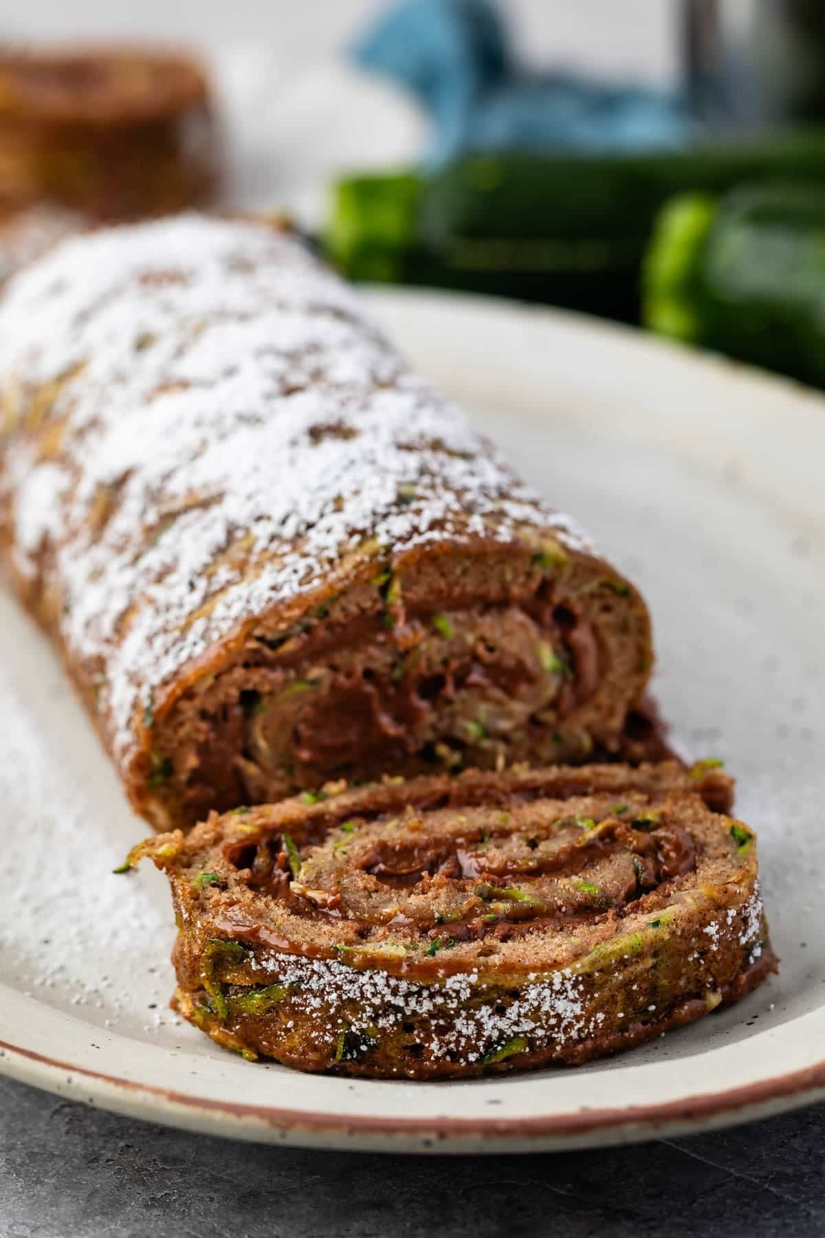 sliced cake roll with chocolate filling and powdered sugar sprinkled on top.