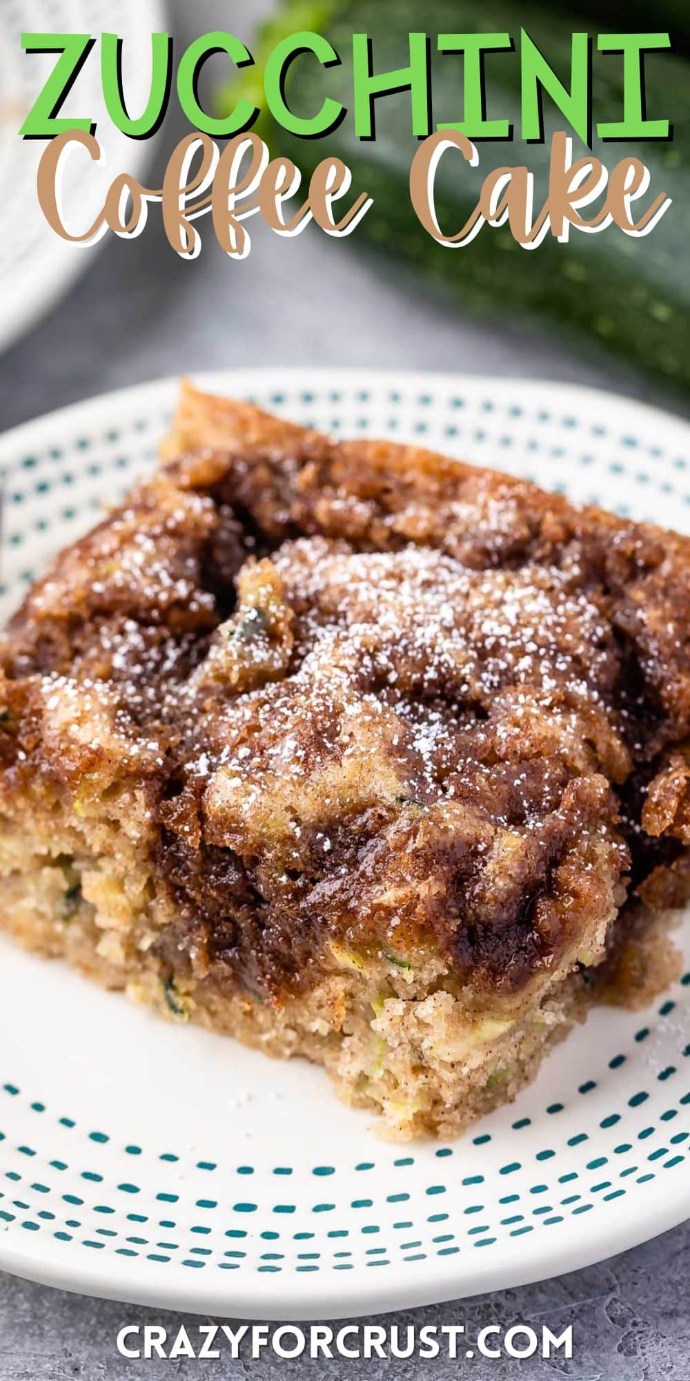 slice of square coffee cake on a white plate with powdered sugar on top with words on the image.