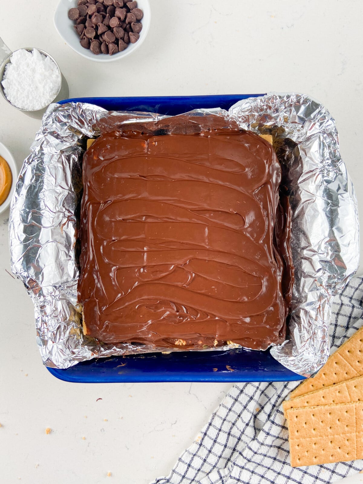 bars in pan with foil lining and chocolate on top