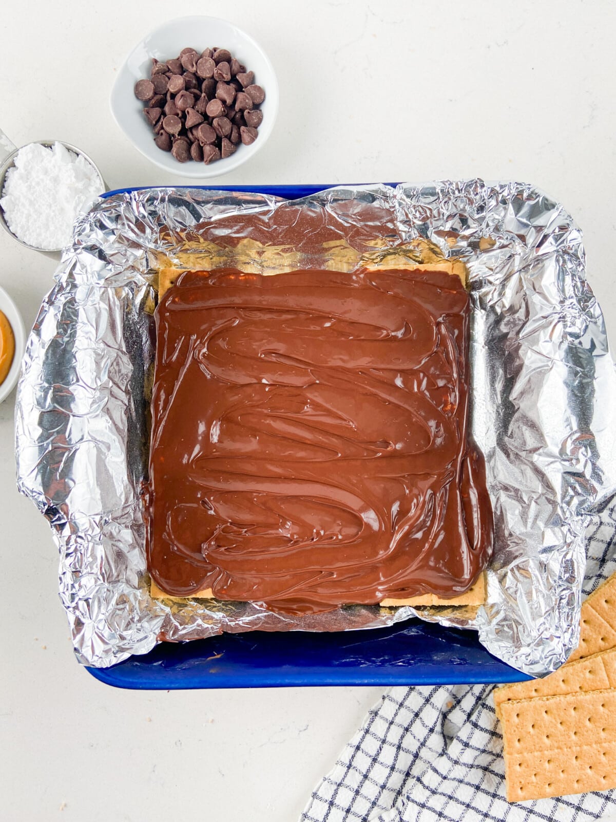 chocolate spread on graham crackers in foil lined pan