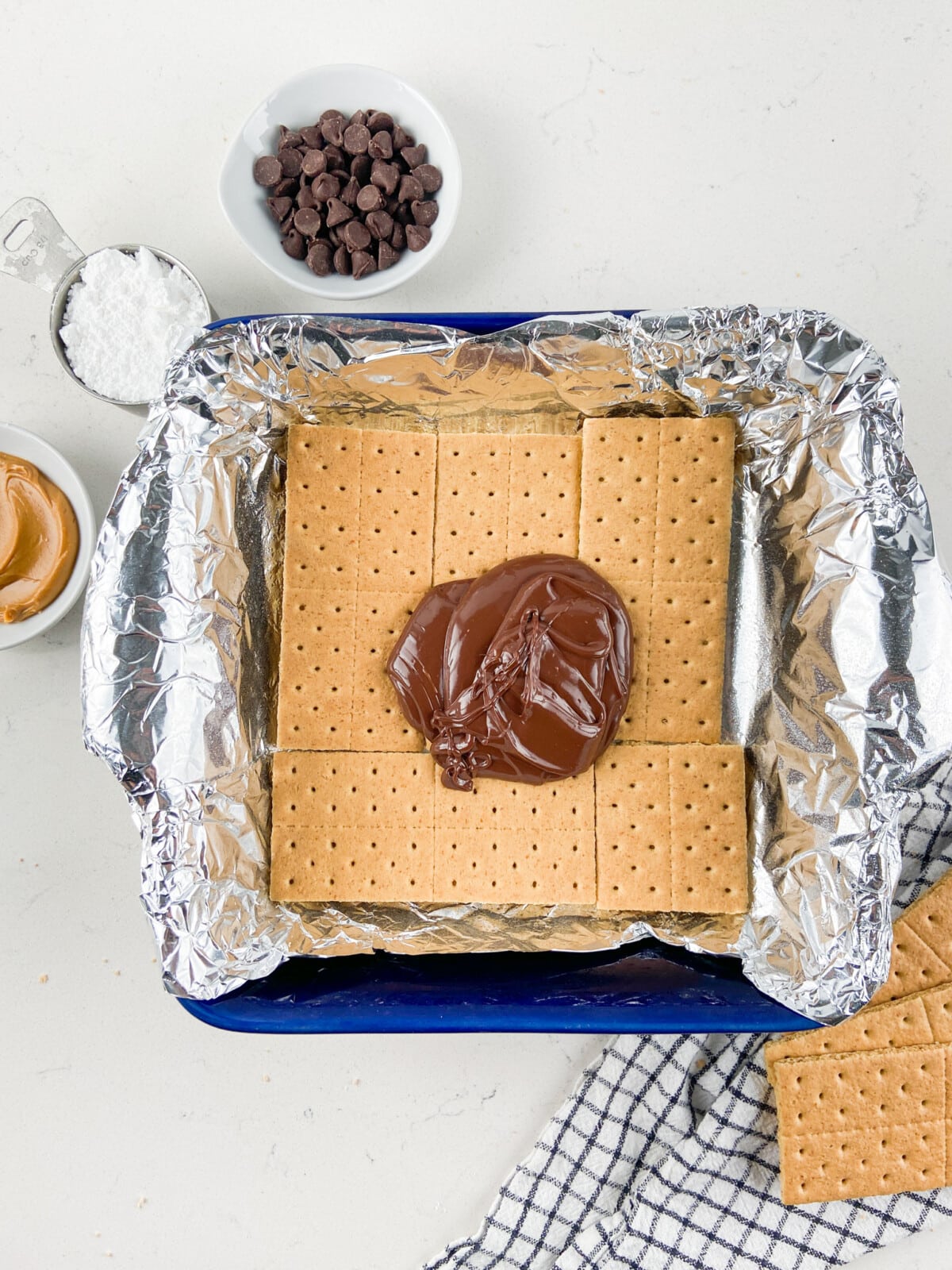 graham crackers with blob of chocolate in foil lined pan