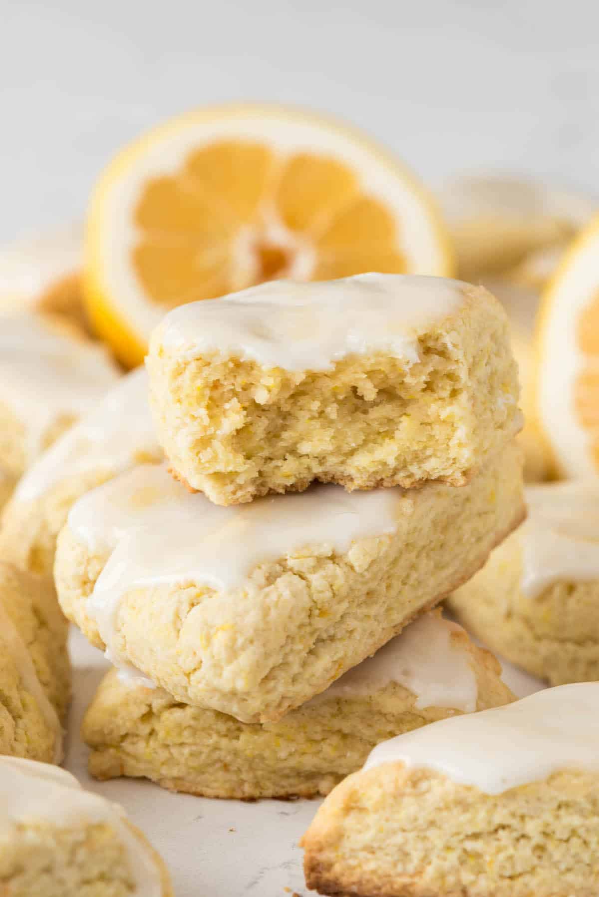 stacked lemon scones with vanilla icing on top.