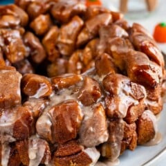 monkey bread on a grey plate with icing dripped over the top.