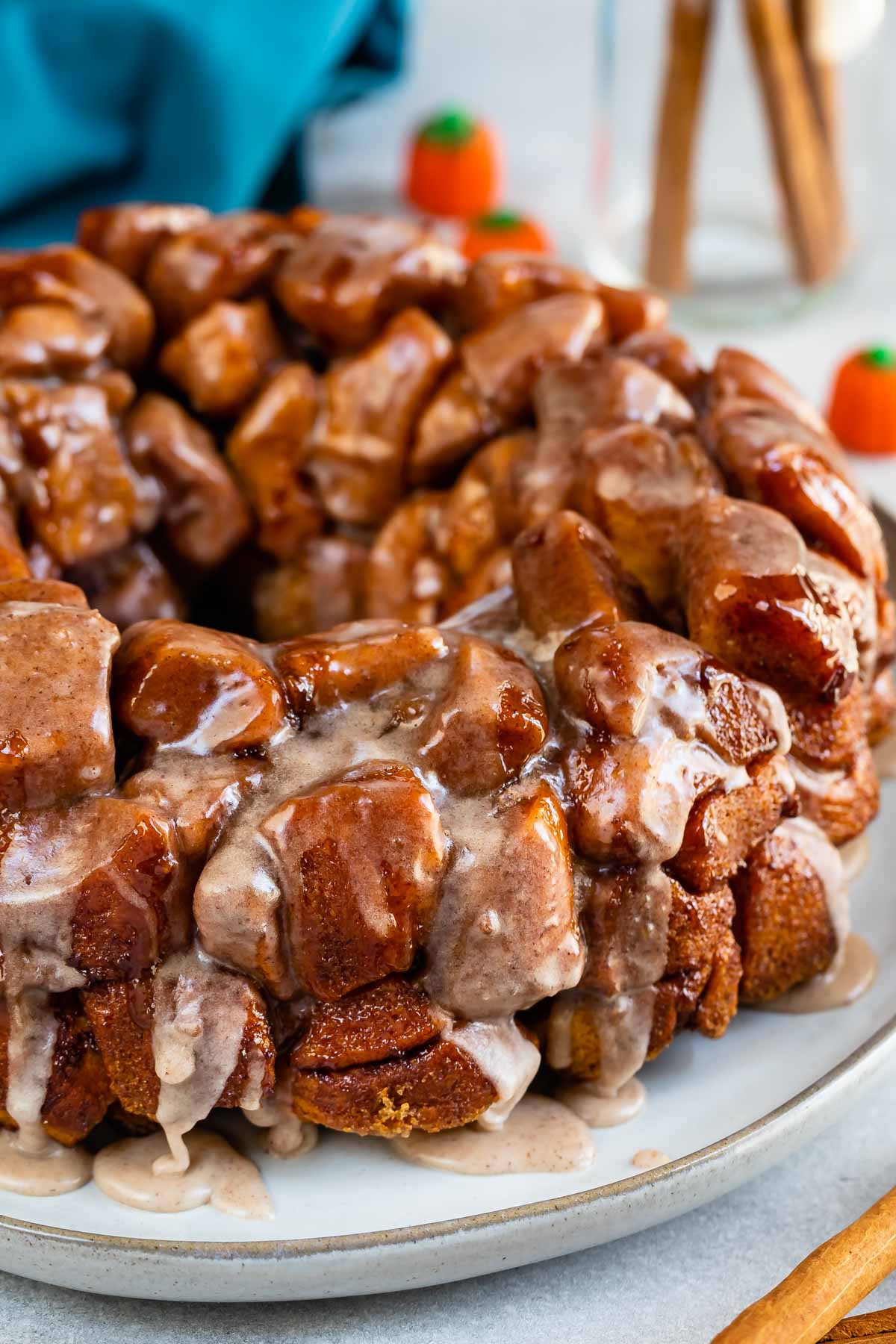 monkey bread on a grey plate with icing dripped over the top.