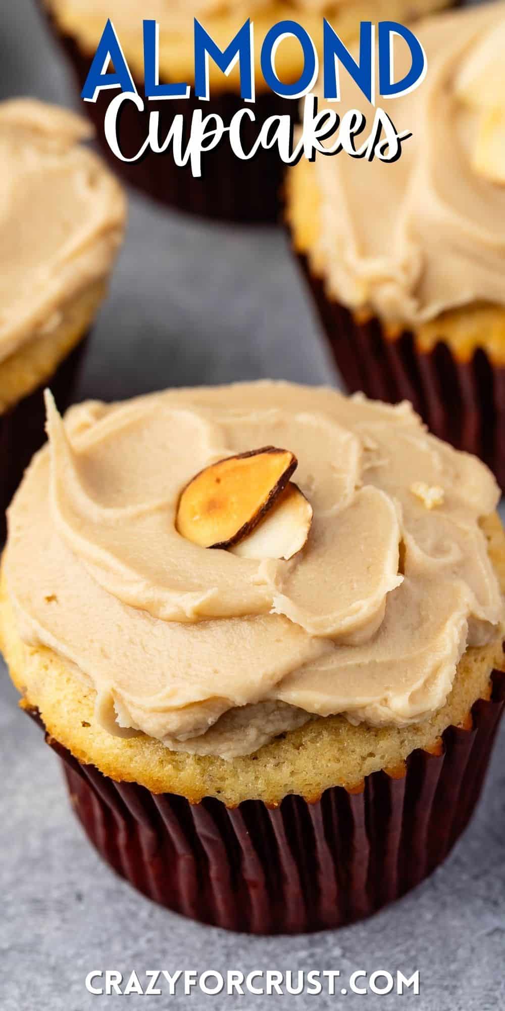 almond cupcake with brown frosting with an almond slice on top with words on the image.