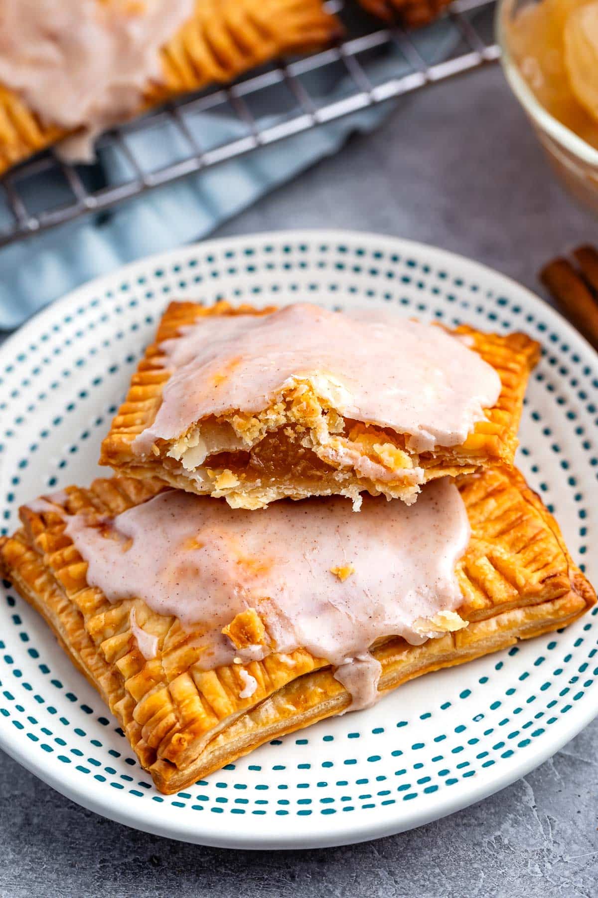 pop tarts on a white plate with one pop tart cut in half revealing apple pie filling.