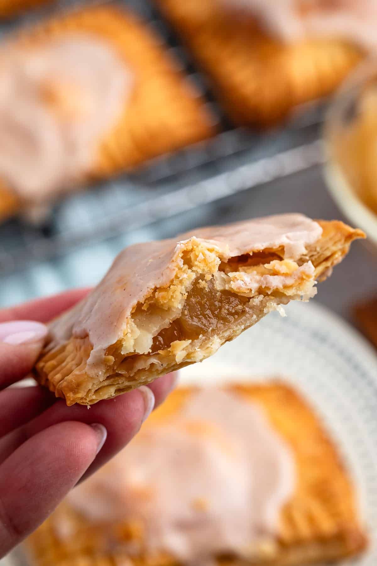 pop tarts on a white plate with one pop tart cut in half revealing apple pie filling.