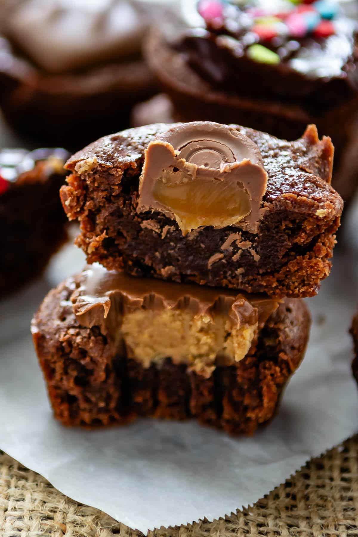 stacked brownie bites on parchment paper with Reeses in the center.
