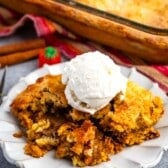 dump cake on a grey plate with ice cream scoop on top.