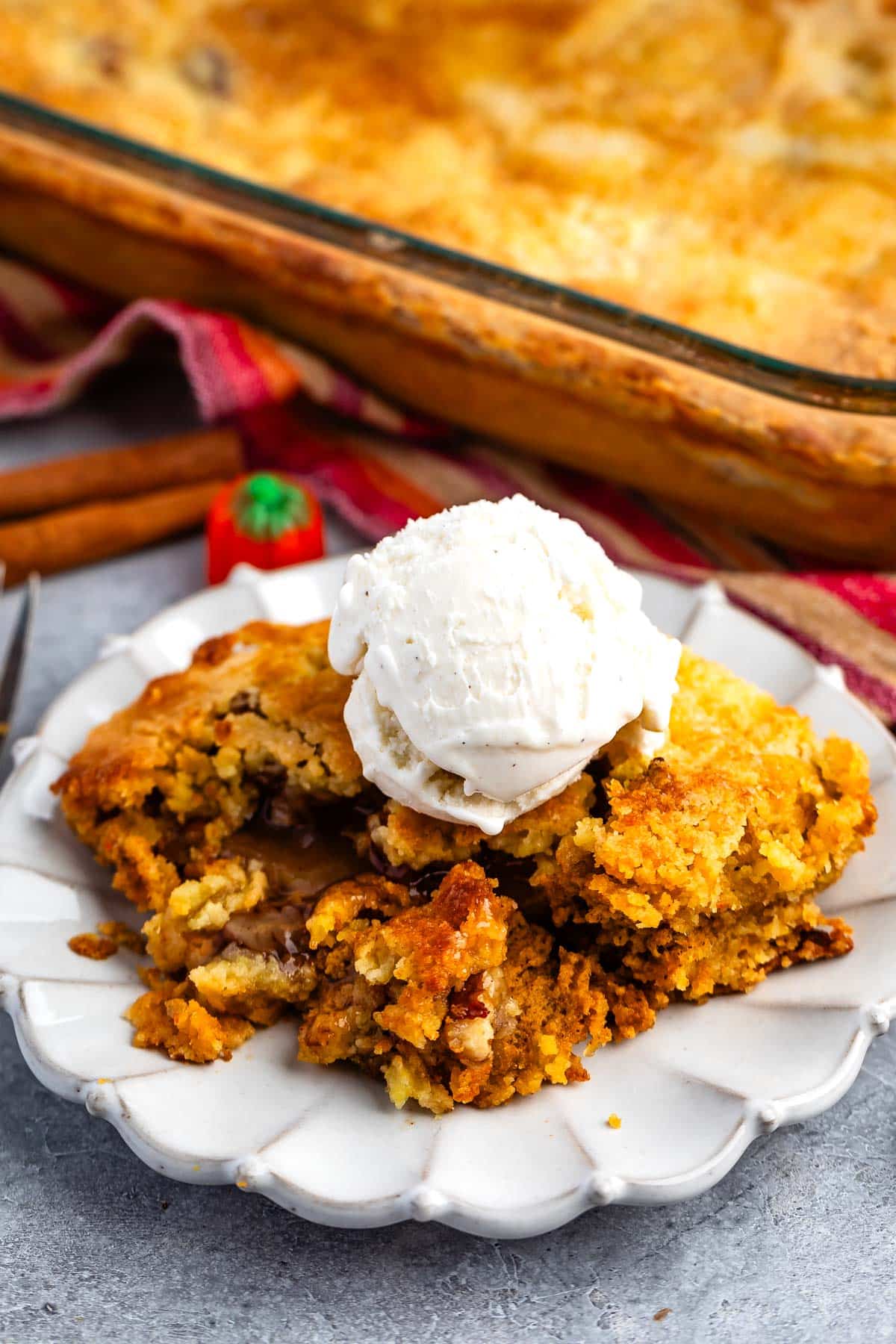 dump cake on a grey plate with ice cream scoop on top.