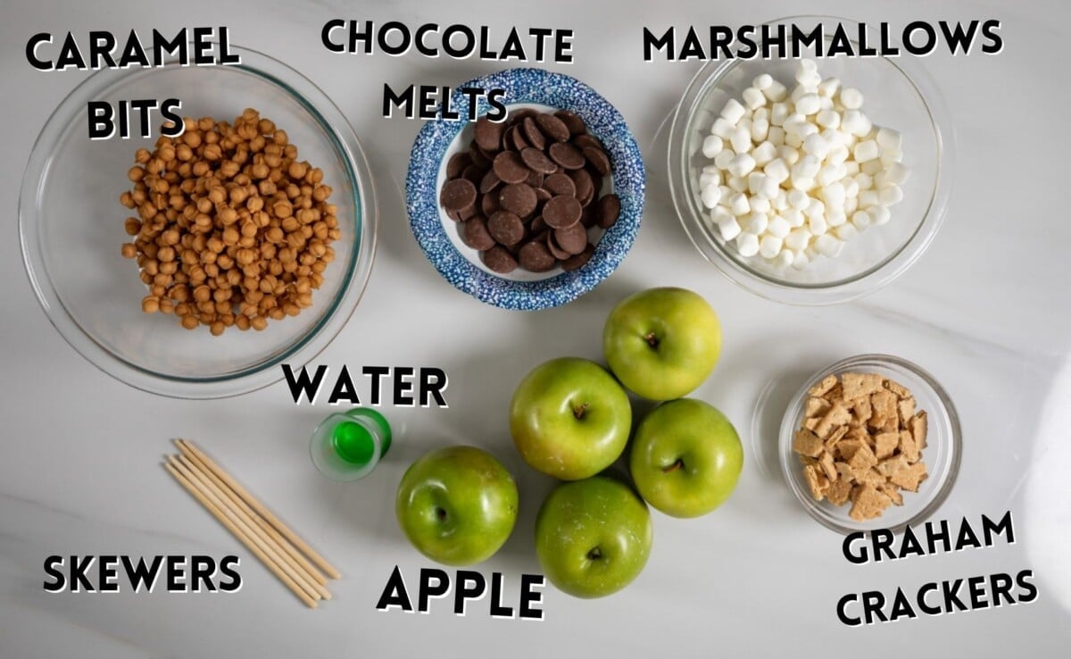 ingredients in s'more caramel apples laid out on a marble counter.