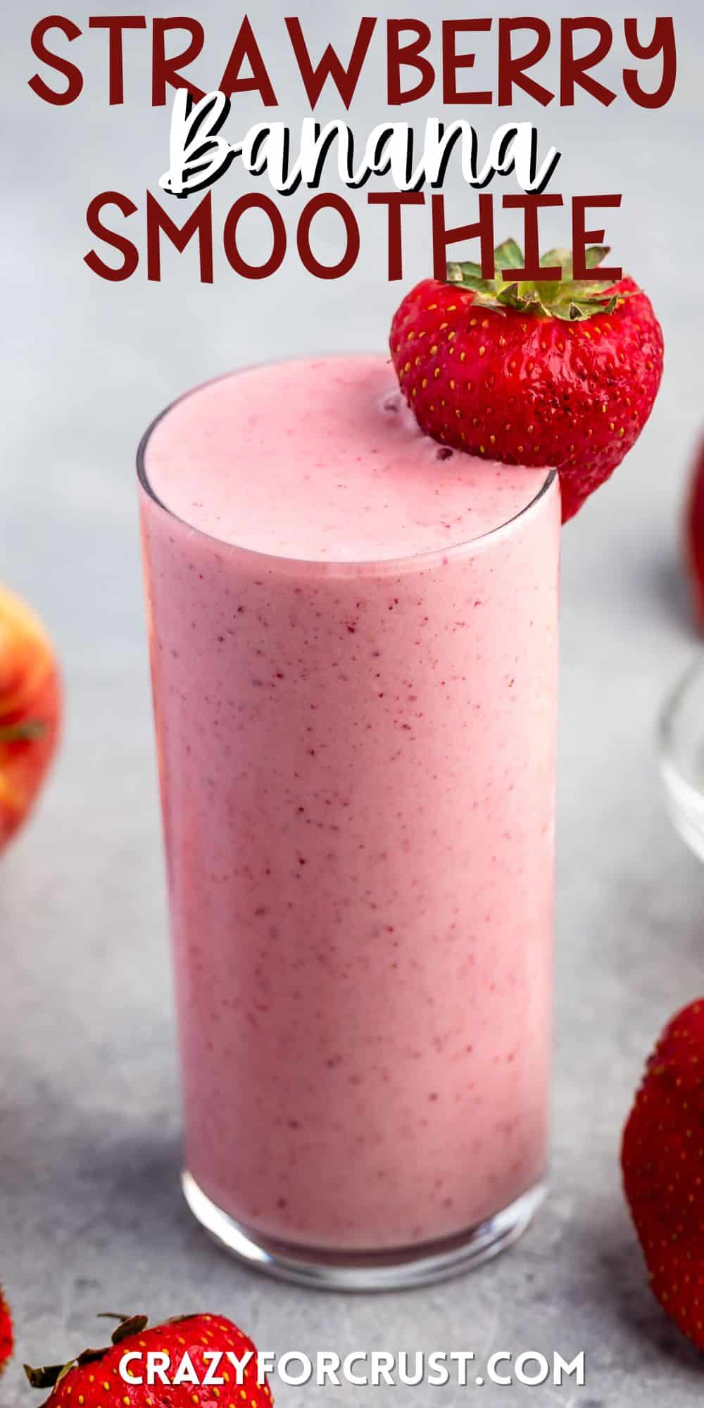 tall clear glass holding light pink smoothie with a strawberry on the rim with words on the image.