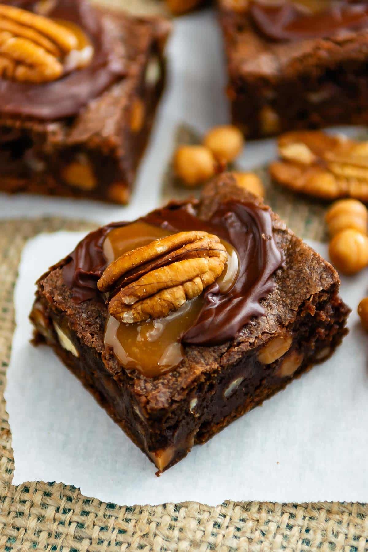 brownies with caramel and a pecan on top.