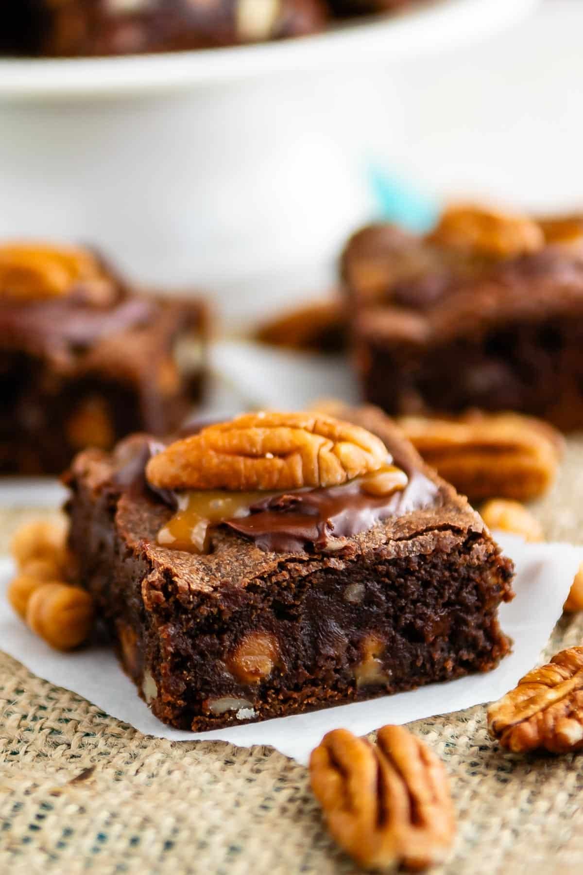 brownies with caramel and a pecan on top.
