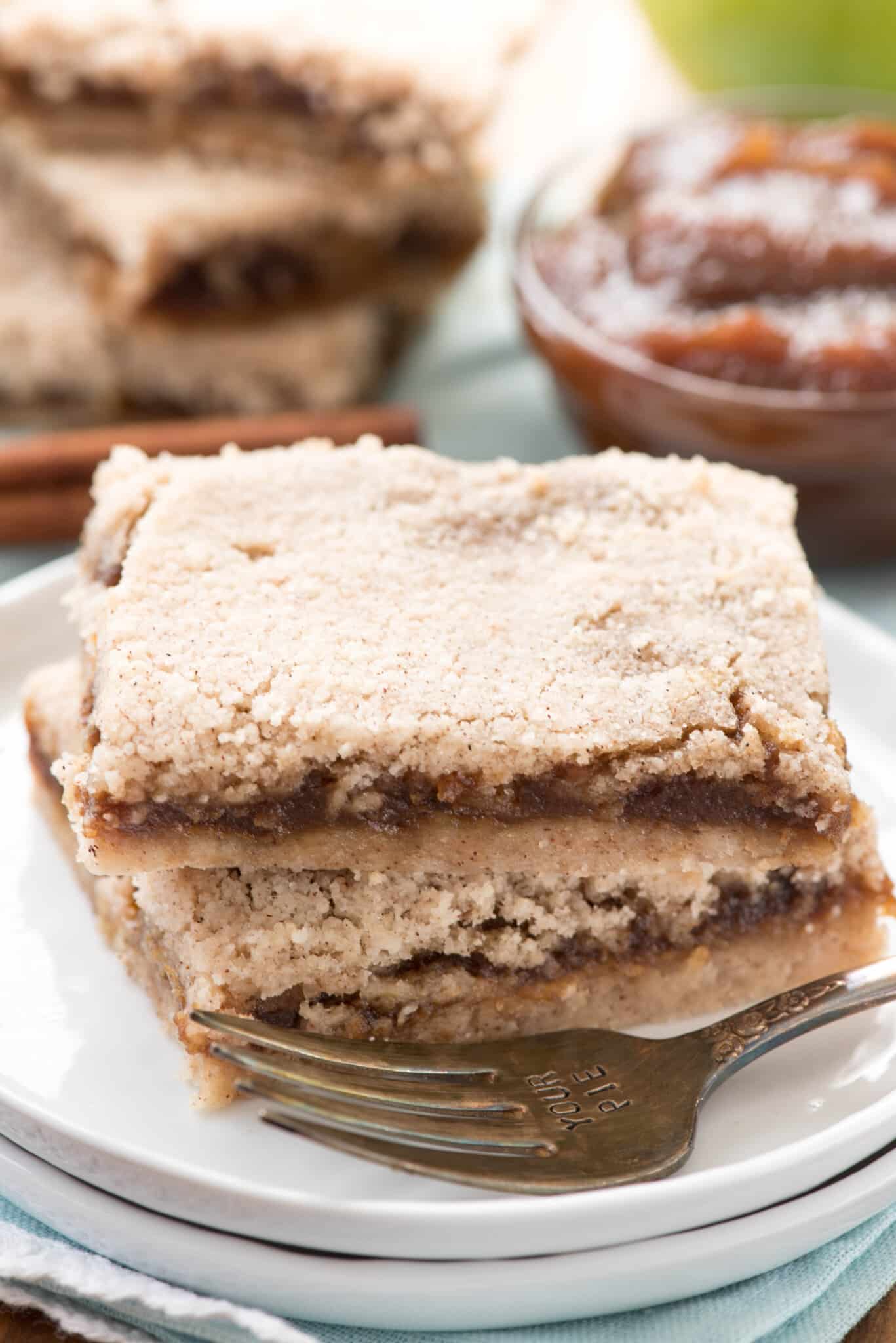 brown layered bars stacked on a white plate.