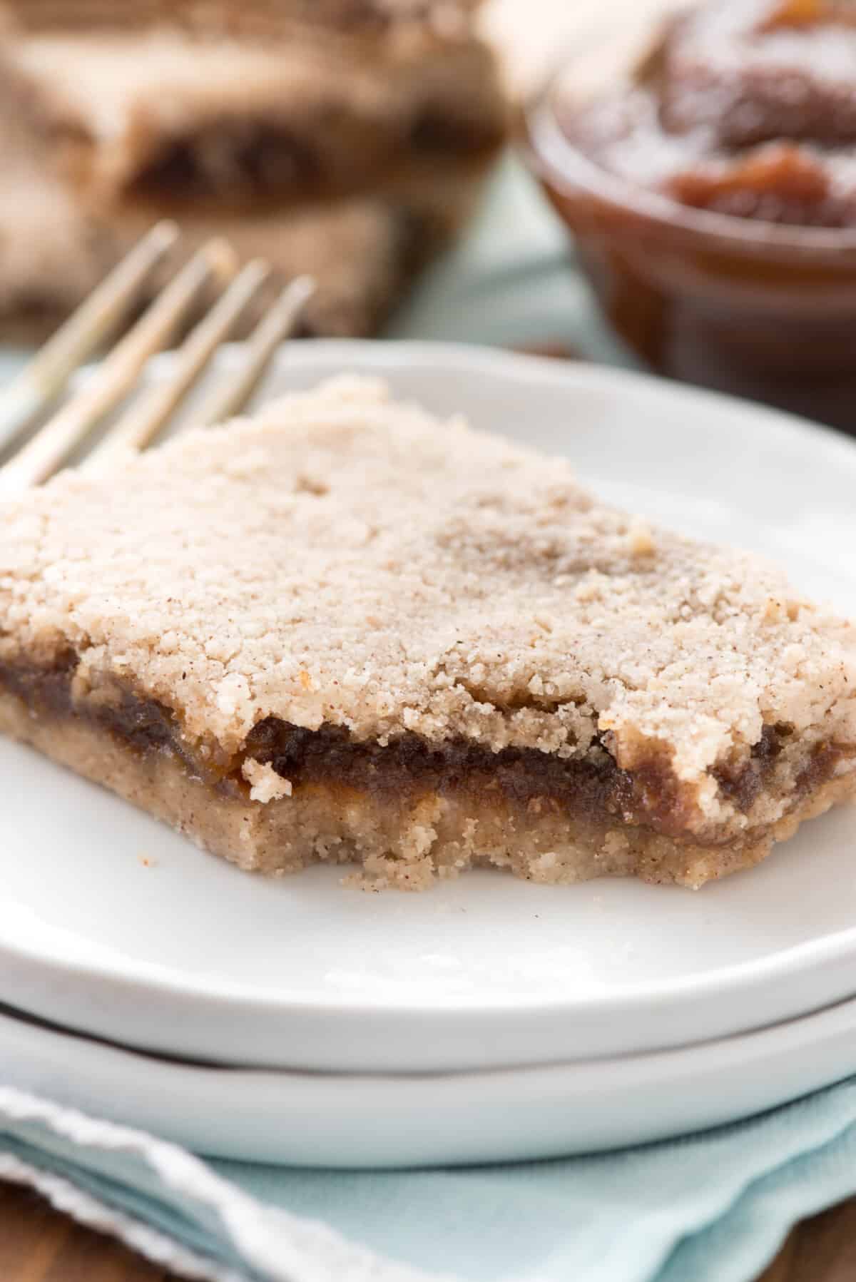 brown layered bars stacked on a white plate.