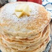 stacked pancakes with apple slices on top.