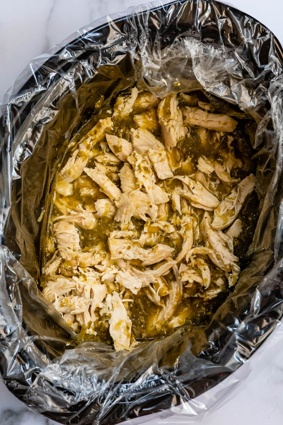 shredded chicken in green salsa in crockpot.