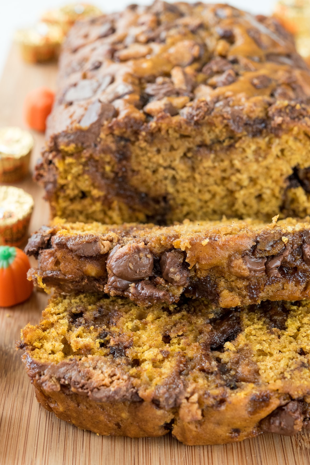 sliced pumpkin bread with chocolate chips baked in on a cutting board.