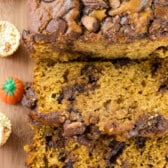 sliced pumpkin bread with chocolate chips baked in on a cutting board.