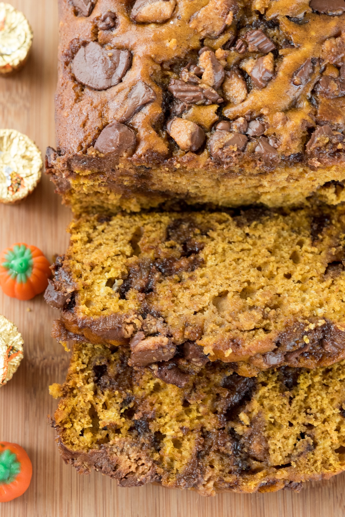 sliced pumpkin bread with chocolate chips baked in on a cutting board.