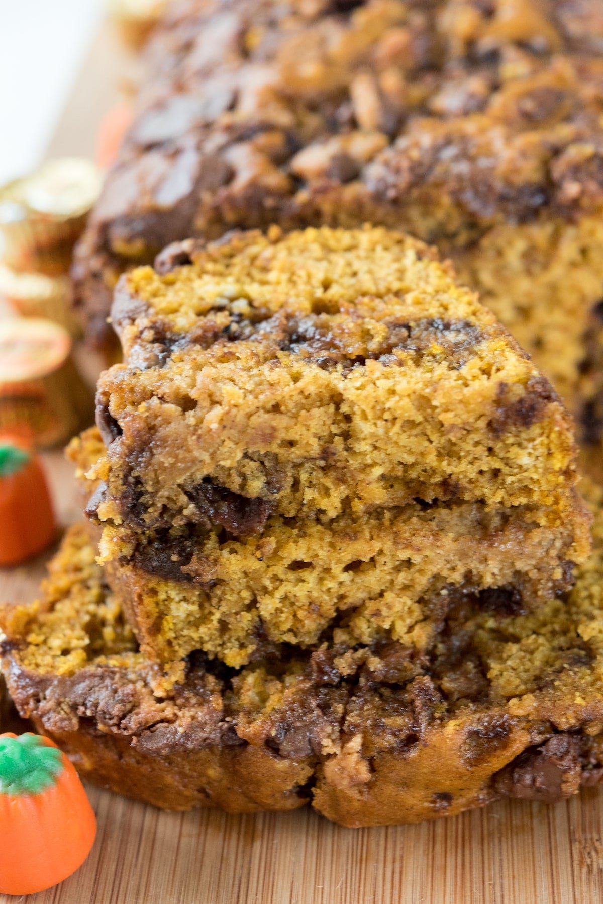 sliced pumpkin bread with chocolate chips baked in on a cutting board.