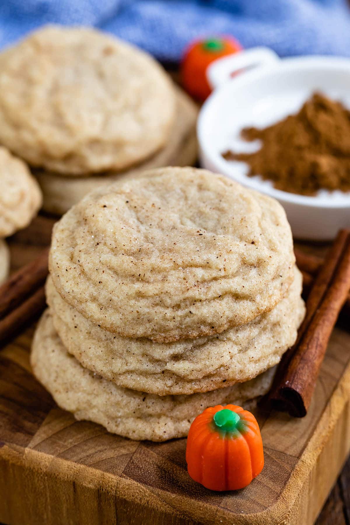 stacked cookies on a cutting board next to pumpkin candy corn.