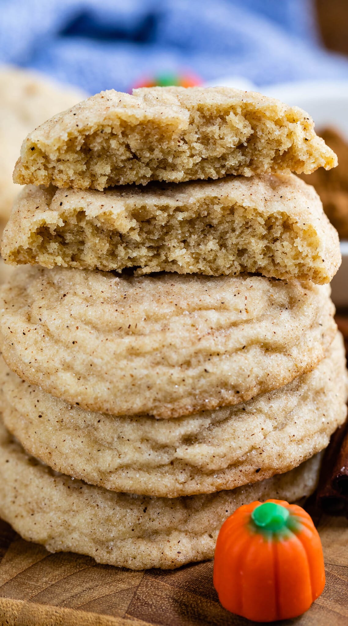 stacked cookies on a cutting board next to pumpkin candy corn.