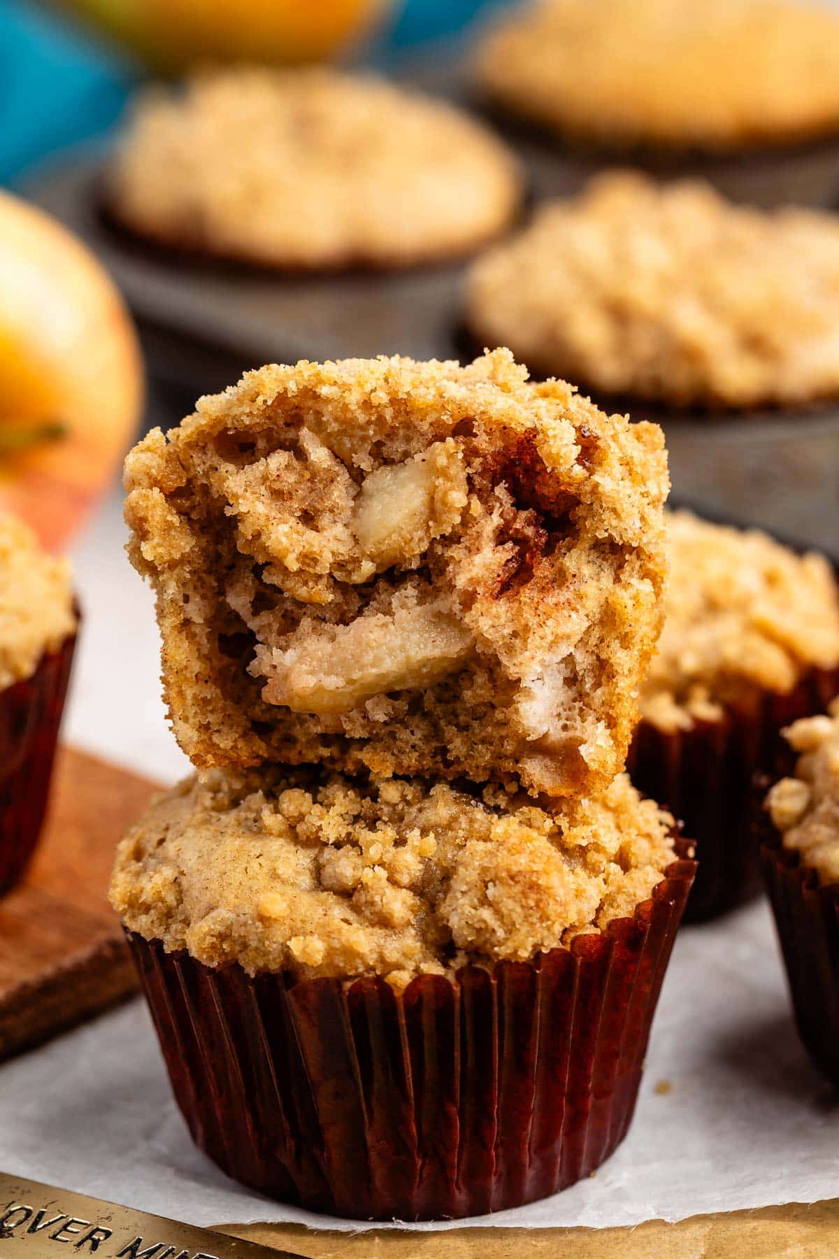 apple muffins in a brown cupcake tin with a crumble topping.