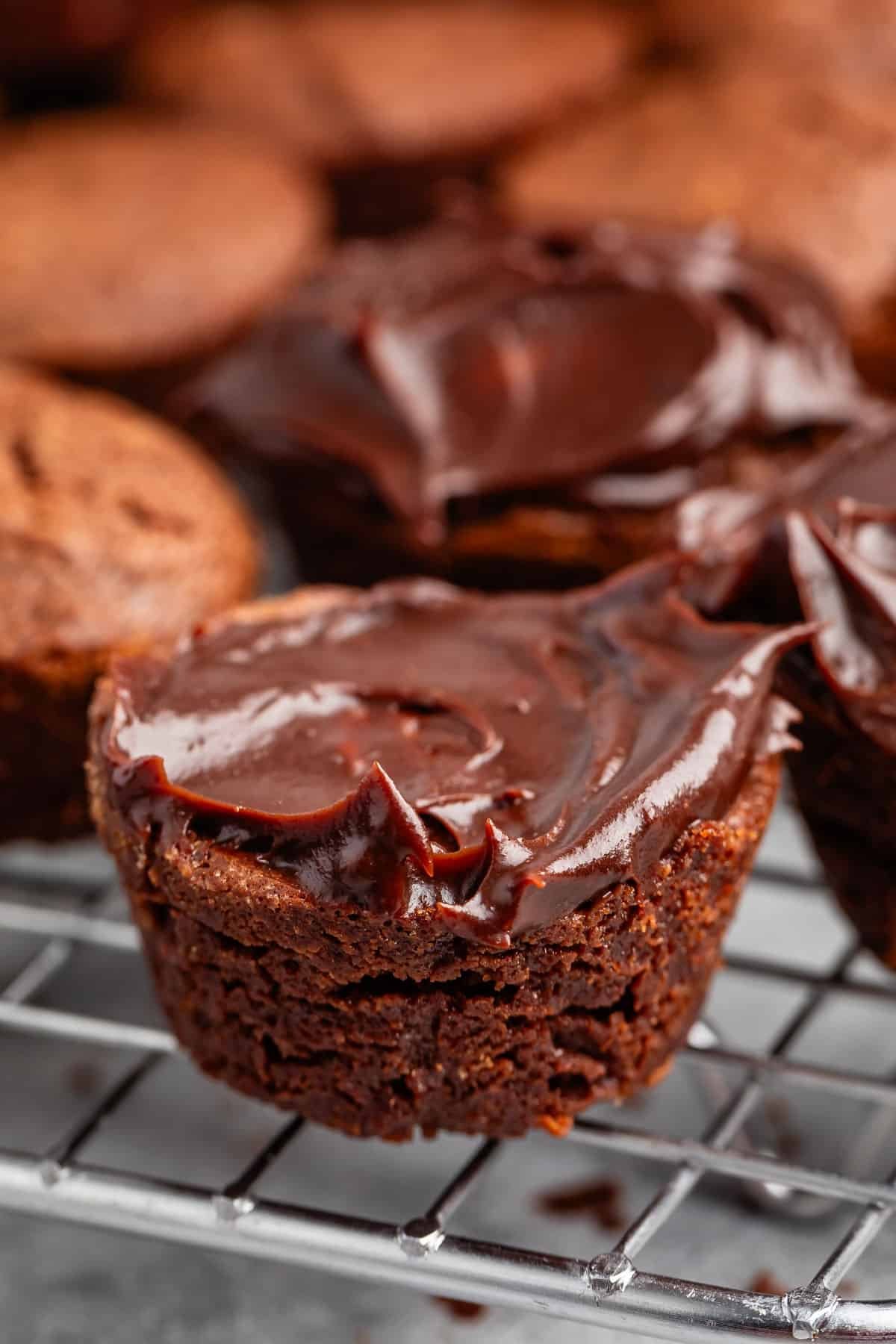 brownie bites layered on a drying wrack with chocolate in the top.