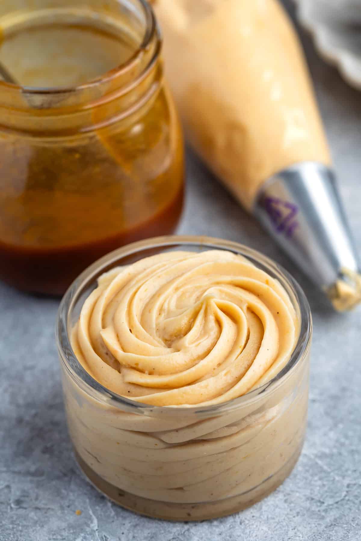 caramel frosting piped into a clear jar.