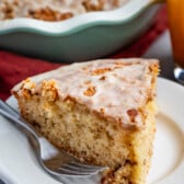 apple fritter coffee cake in a white pan with glaze on top.