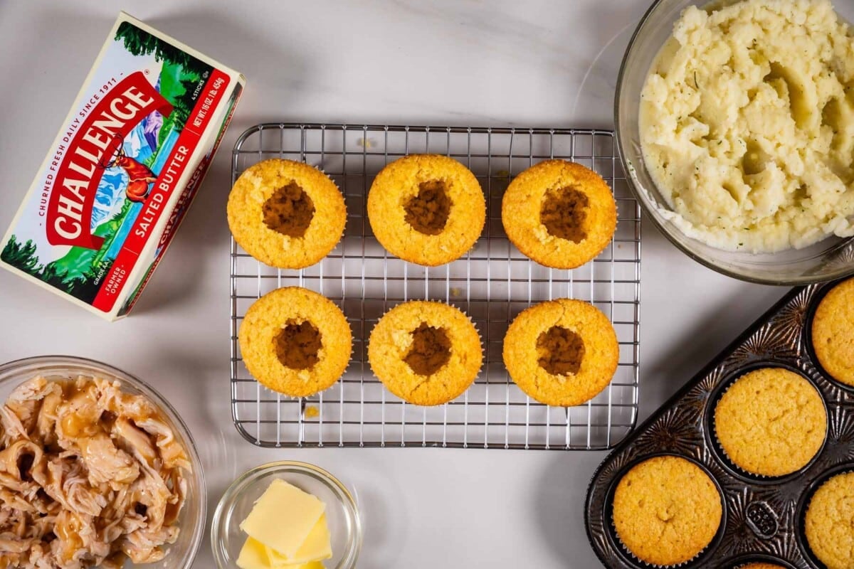 6 cupcakes on a rack frosted with centers cut out and butter box and ingredients around.