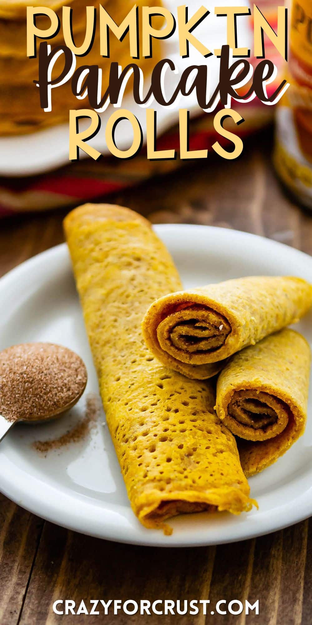 pumpkin pancakes rolled up on a white plate with words on the image.