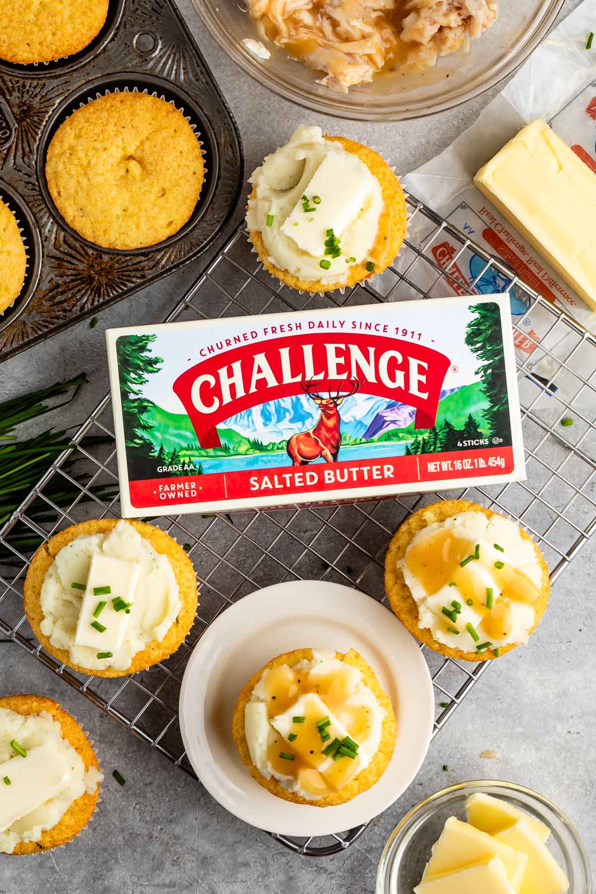 photo showing cupcakes on a rack and one on a little white plate with butter box in the middle.