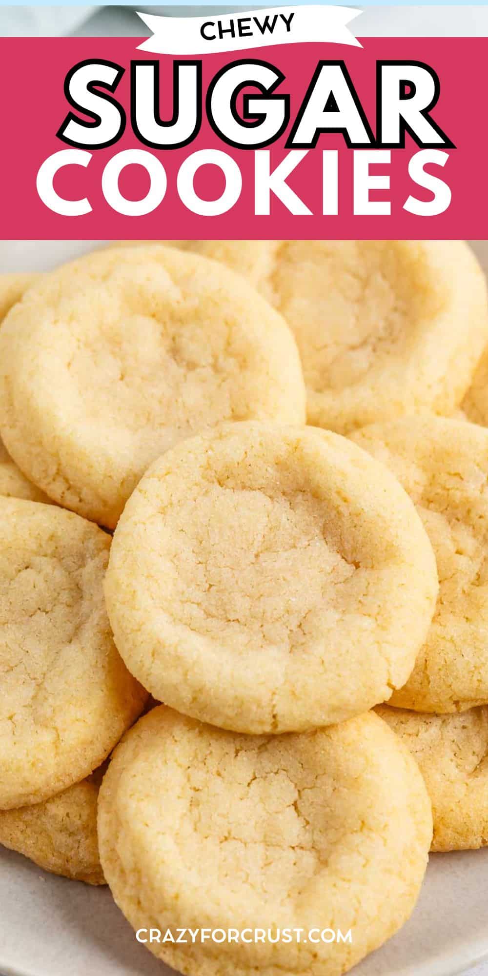 Une assiette remplie de nombreux biscuits ronds légèrement dorés avec une surface légèrement craquelée. Le texte ci-dessus indique Chewy Sugar Cookies et une recette facile de biscuits au sucre de Crazyforcrust.com ci-dessous.